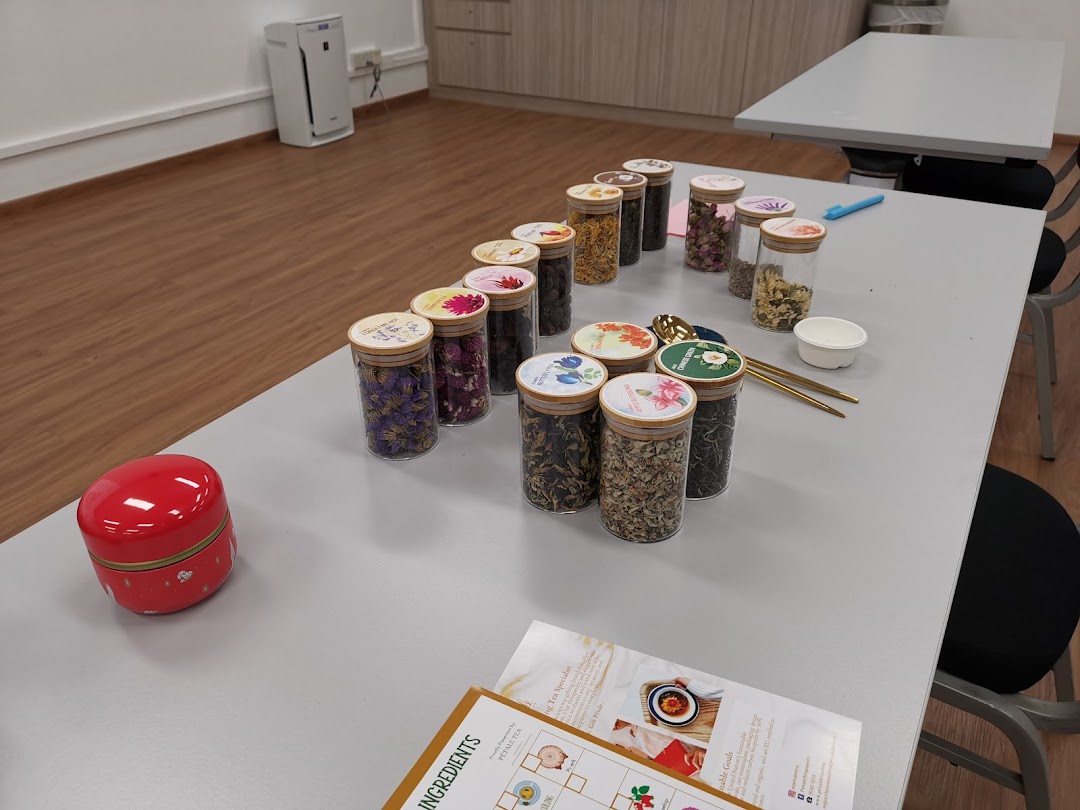 A table displays numerous jars filled with dried flowers and tea leaves, set up for a tea blending activity.