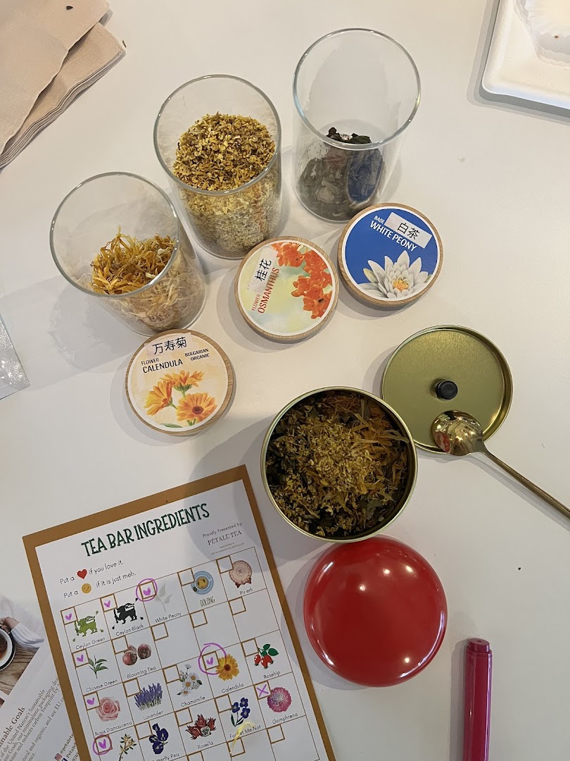 A vibrant display of dried tea ingredients and a 'Tea Bar Ingredients' sheet for custom blending.