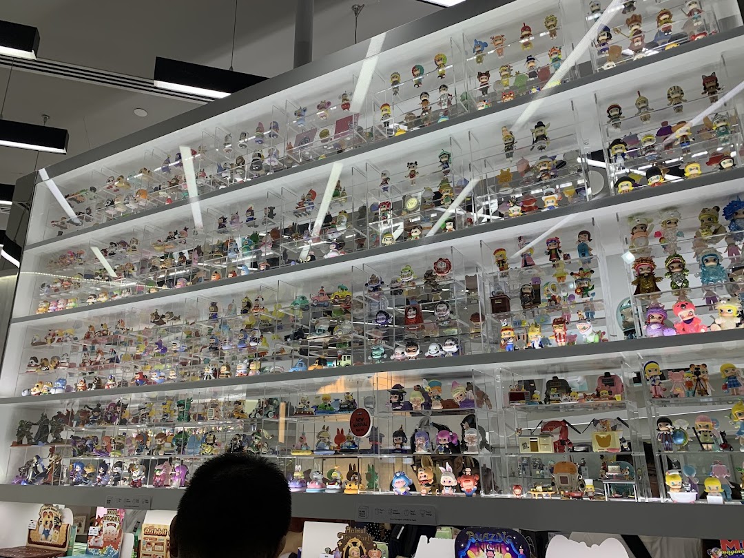 A large display wall showcasing numerous colorful collectible figures and blind box toys at POP MART.