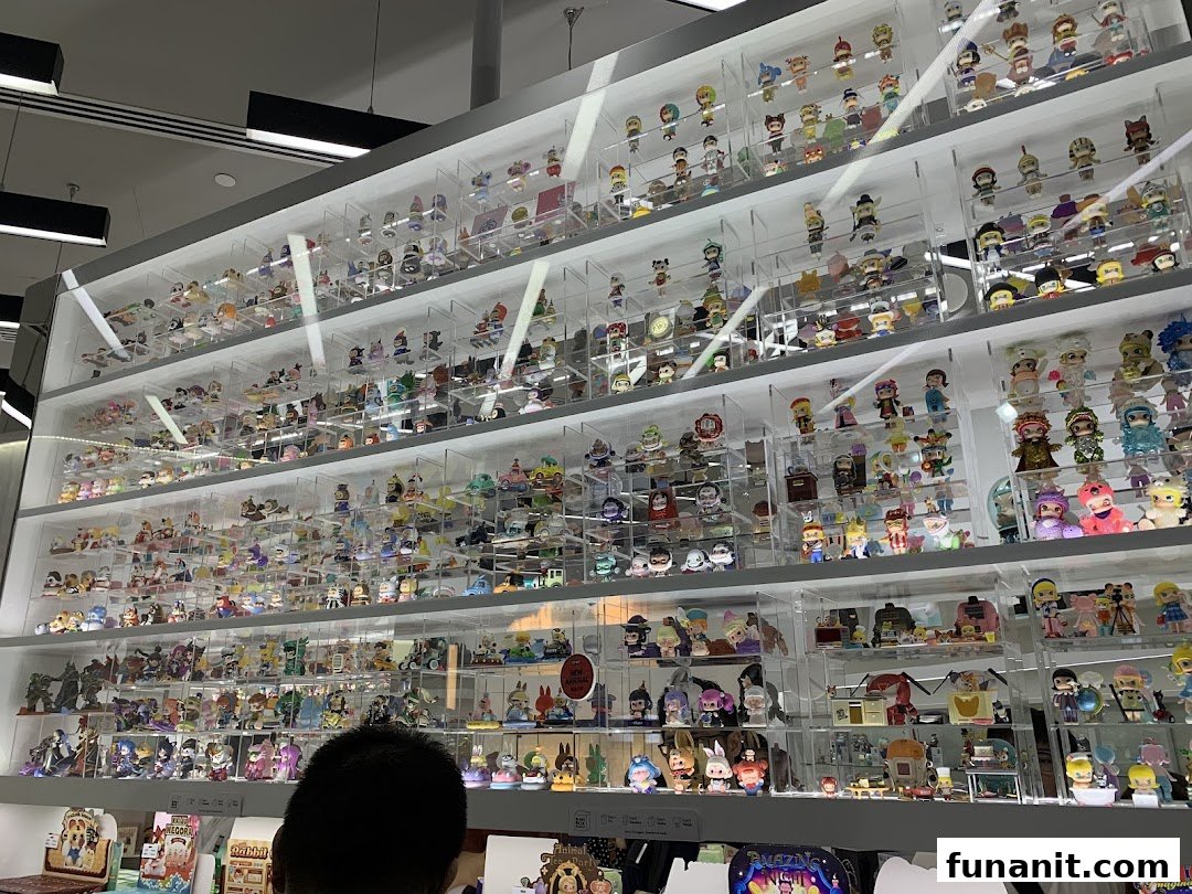 A large display wall showcasing numerous colorful collectible figures and blind box toys at POP MART.