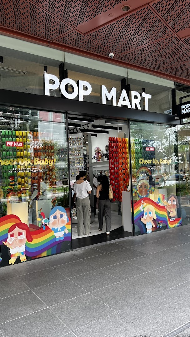 The exterior of POP MART Funan, featuring its logo, colorful window displays, and customers entering the store.