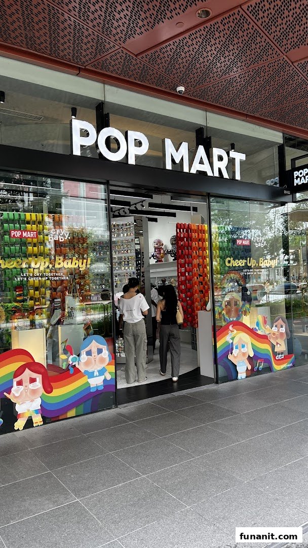 The exterior of POP MART Funan, featuring its logo, colorful window displays, and customers entering the store.