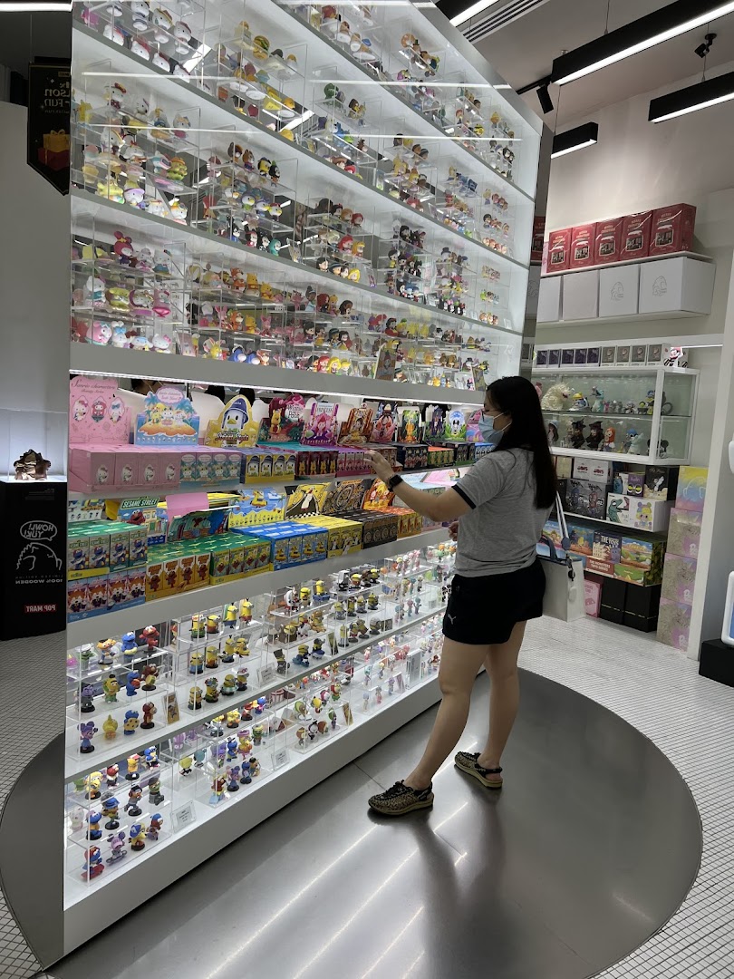 A customer browses a large display of collectible figurines and blind boxes at POP MART.