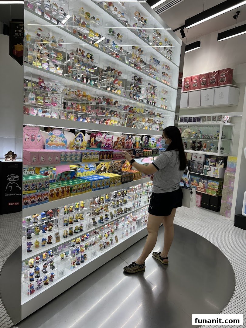 A customer browses a large display of collectible figurines and blind boxes at POP MART.
