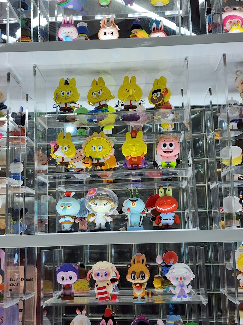 Close-up of diverse collectible art toys and blind box figures displayed on clear shelves at POP MART.