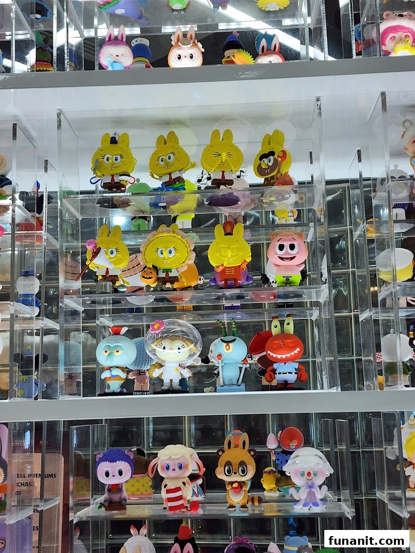 Close-up of diverse collectible art toys and blind box figures displayed on clear shelves at POP MART.