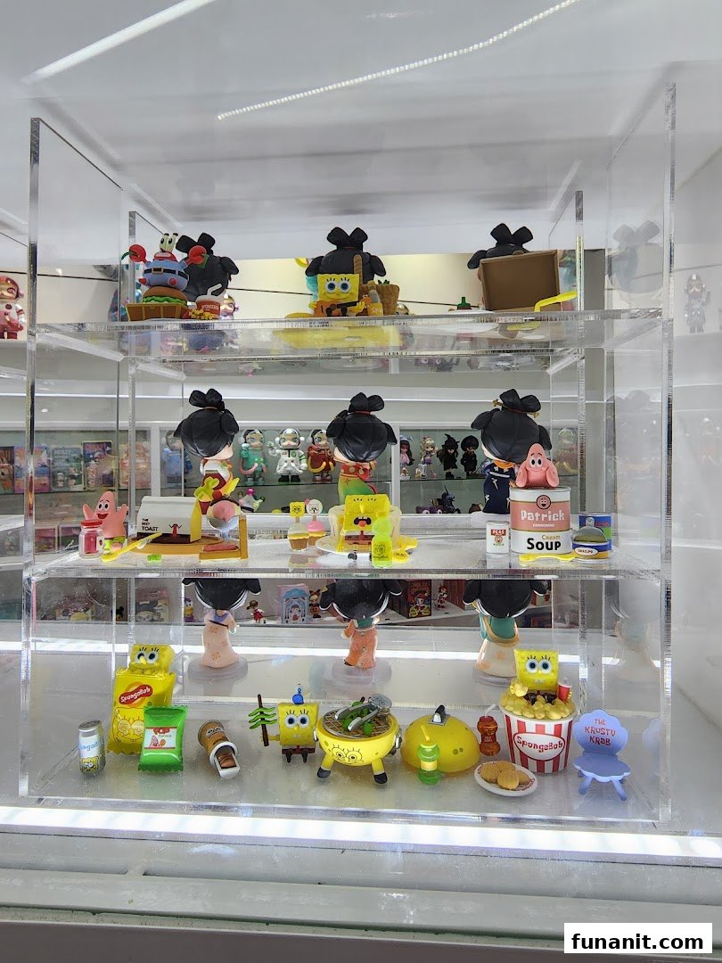 A clear display case showcasing various Spongebob Squarepants collectible figures and accessories inside POP MART.