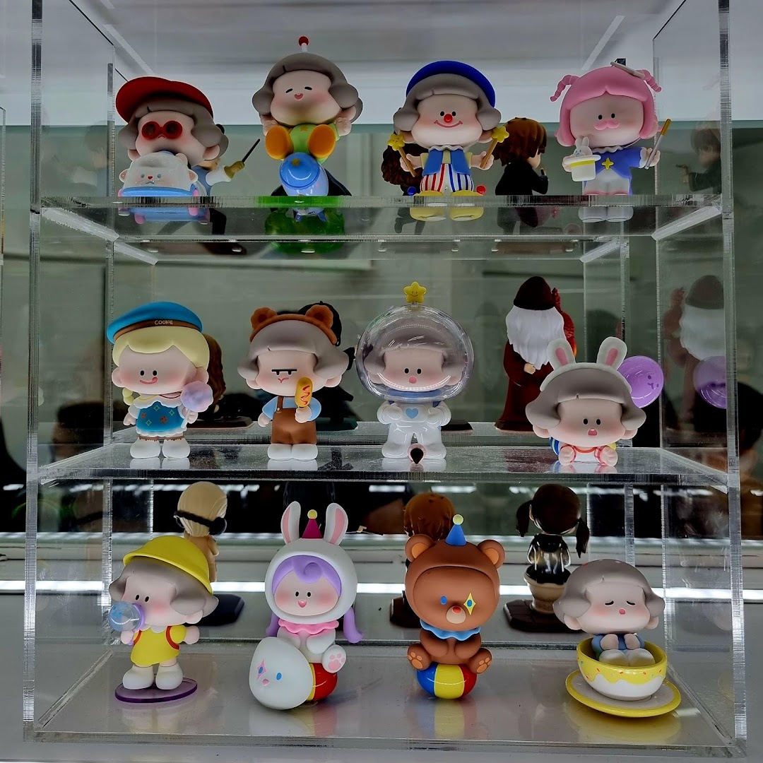 A clear display case showcasing various colorful, stylized collectible figures from POP MART.