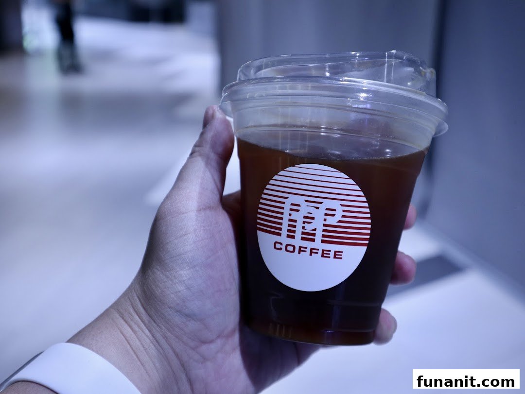 A hand holds a clear plastic cup of iced coffee featuring the distinctive PPP Coffee logo.