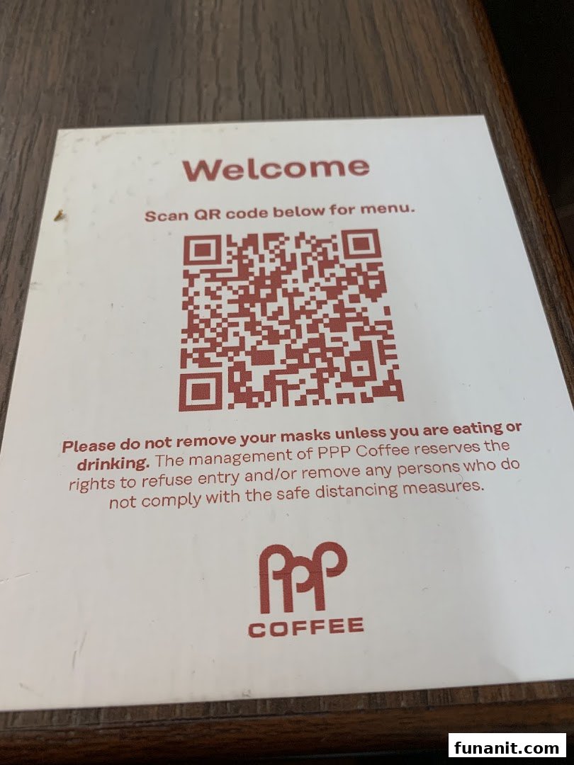 A sign at PPP Coffee displaying a QR code for the menu and mask-wearing guidelines.