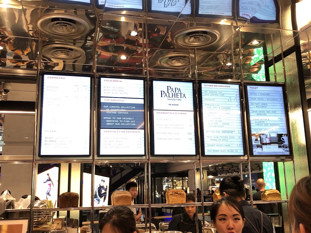 Digital menu boards at PPP Coffee displaying a variety of coffee, beverages, desserts, and toast options.