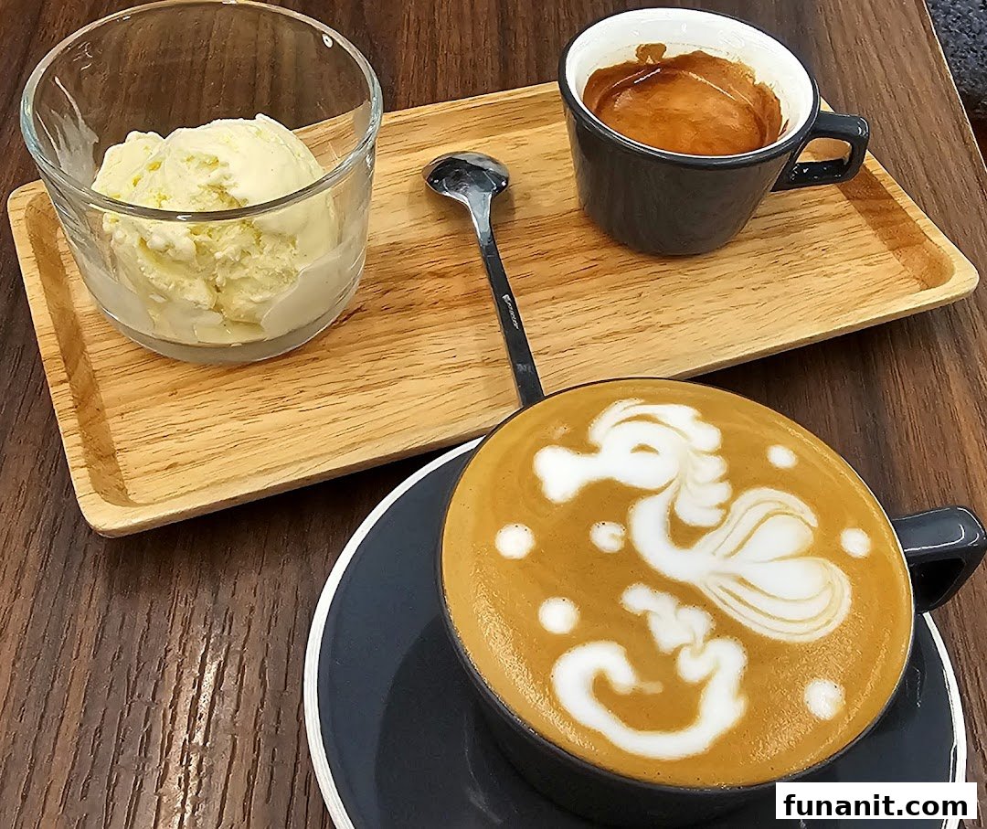 A beautifully crafted latte with seahorse art, an espresso shot, and vanilla ice cream on a wooden tray.
