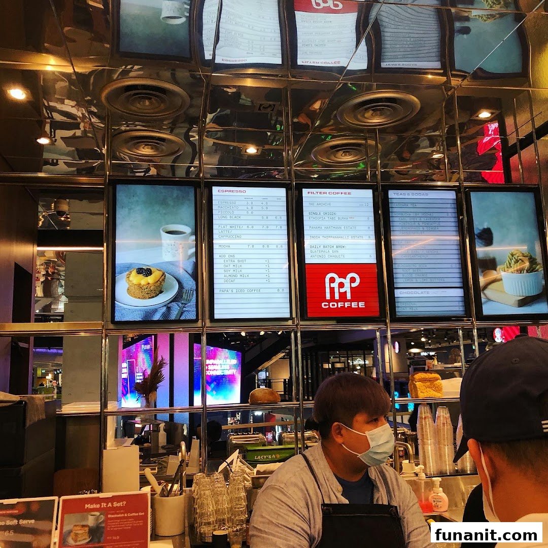 Digital menu boards display coffee and tea options above a bustling counter at PPP Coffee.