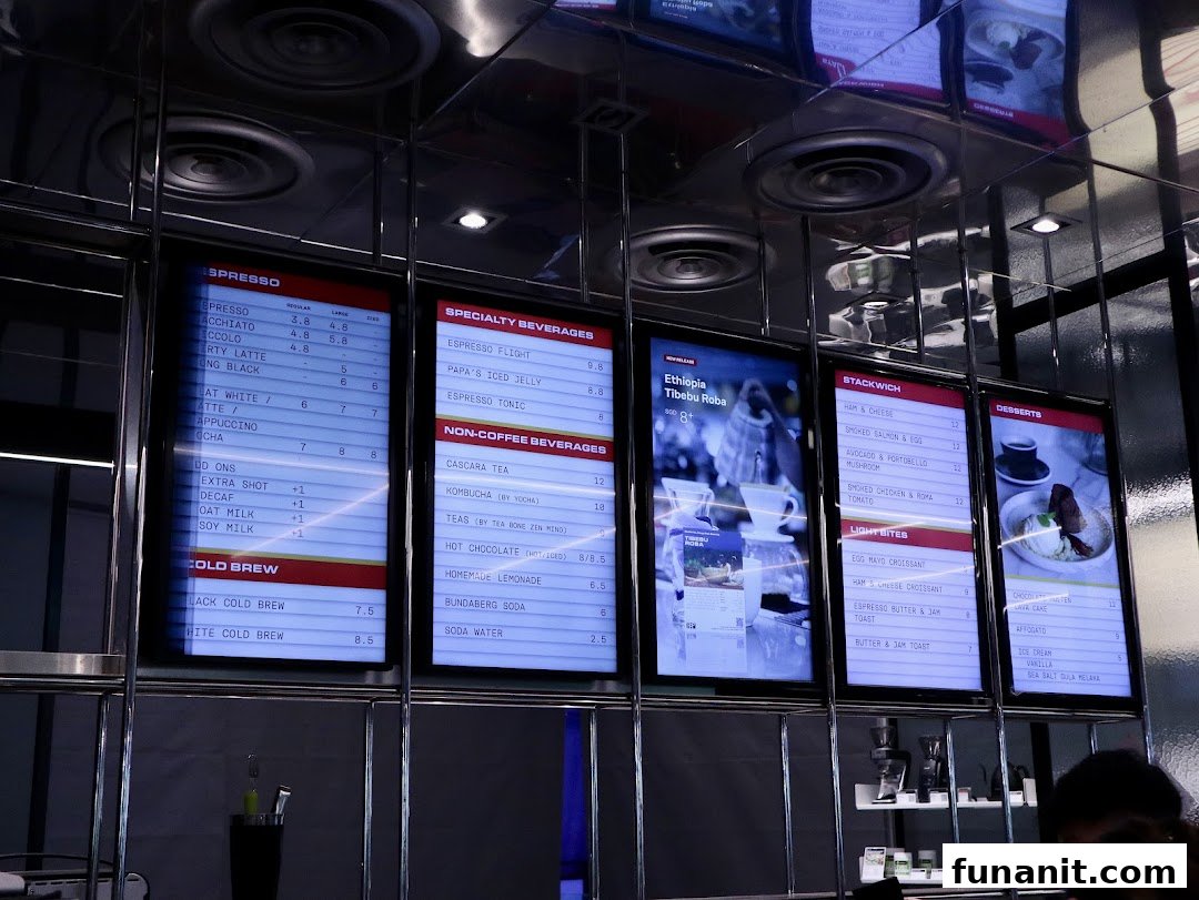 Digital menu boards at PPP Coffee displaying a wide range of coffee, beverages, food, and desserts.