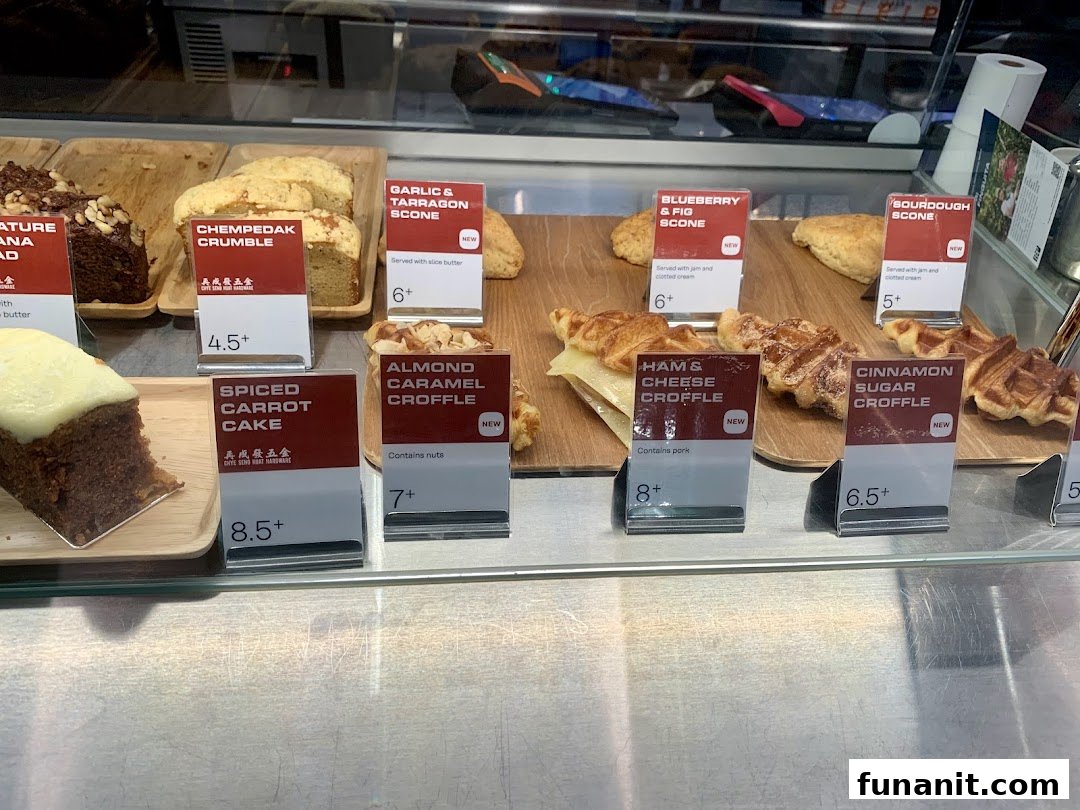 A display case showcasing a variety of freshly baked pastries, cakes, and croffles with price tags.