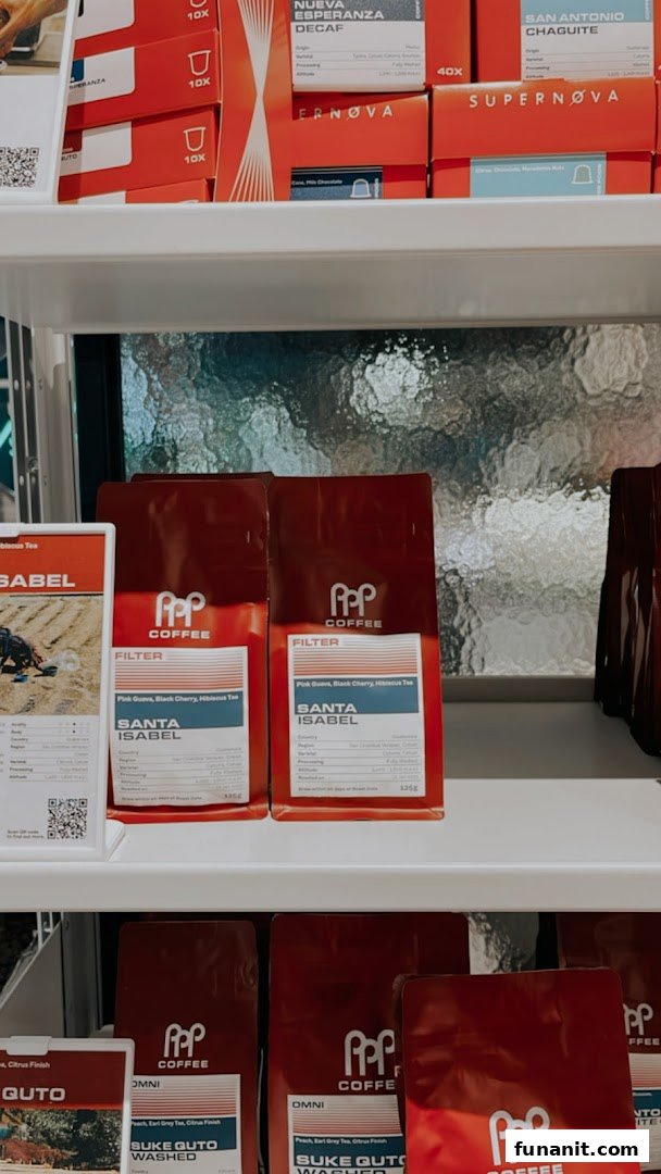 A display of various PPP Coffee products, including coffee beans and capsules, on shelves.