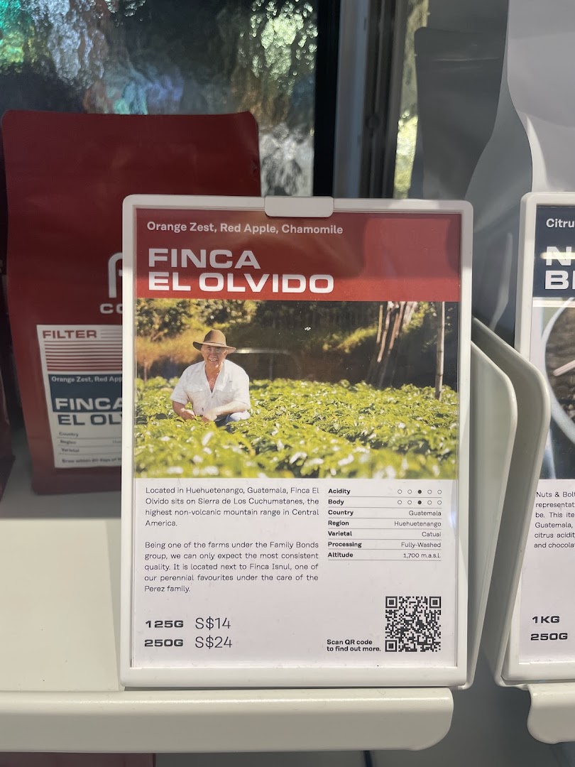 A detailed display card for Finca El Olvido coffee beans, showing origin, tasting notes, and pricing.
