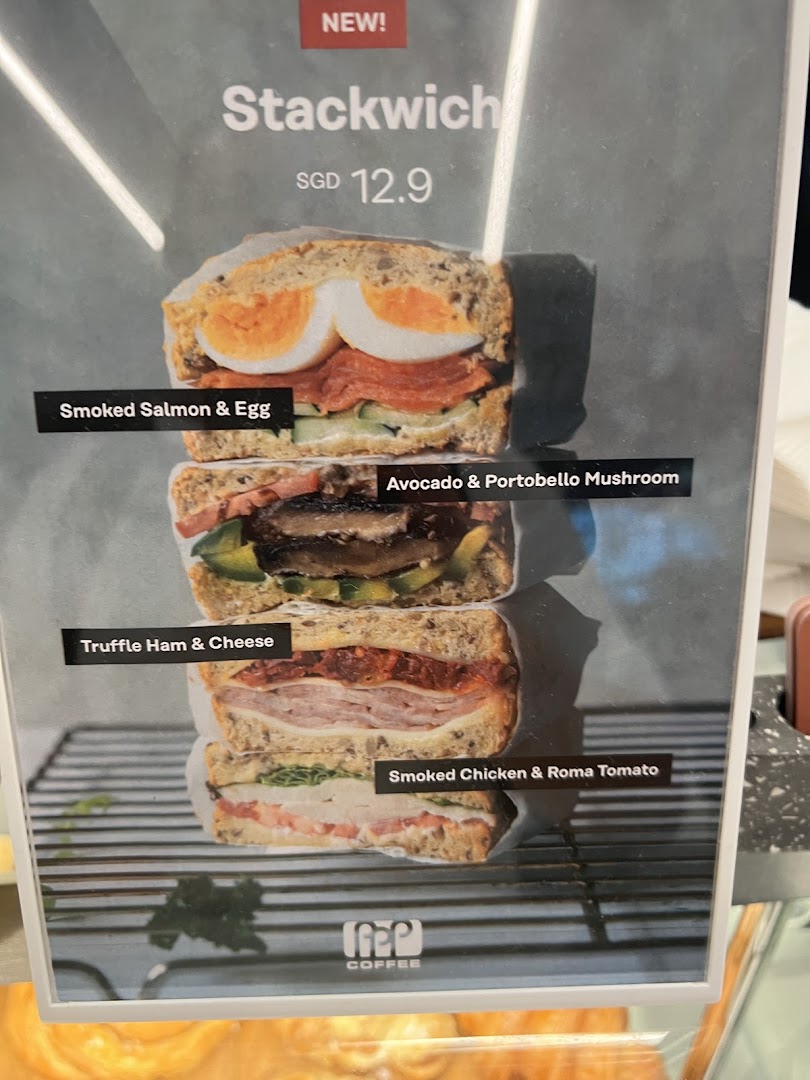A menu board showcasing PPP Coffee's new 'Stackwich' with various gourmet fillings.
