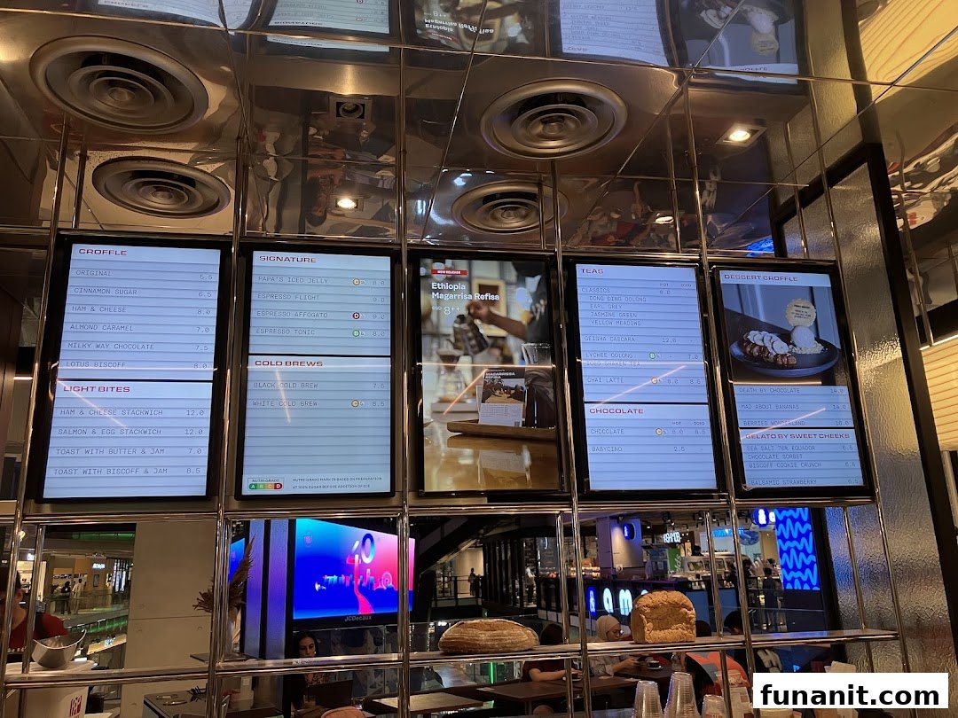 Digital menu boards at PPP Coffee displaying a variety of coffee, tea, croffles, and light bites.