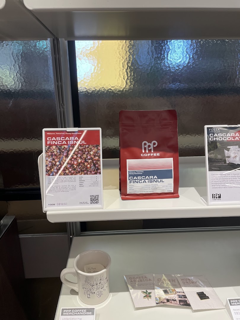 A display shelf at PPP Coffee featuring coffee beans, cascara products, and branded merchandise.