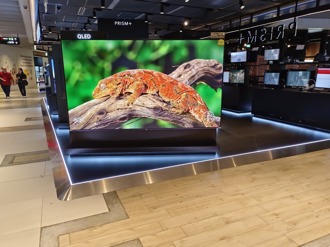 Interior view of PRISM Funan showcasing a large QLED TV display and other electronics.