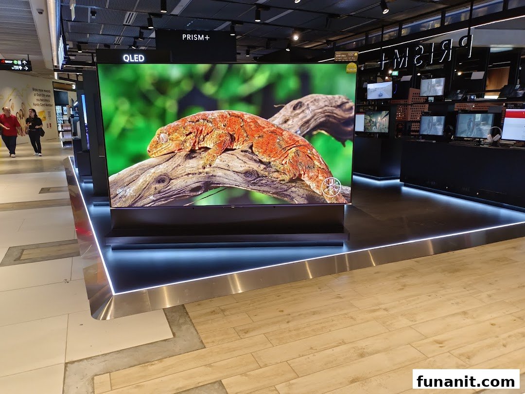 Interior view of PRISM Funan showcasing a large QLED TV display and other electronics.