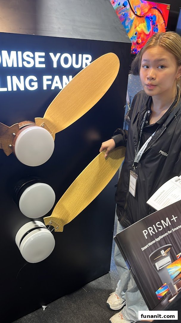 A person stands by a display showcasing PRISM+ smart home appliances and ceiling fans.