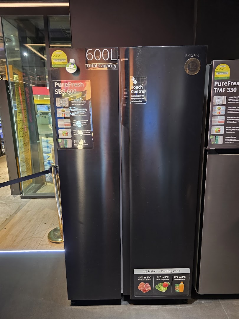 A display of large black refrigerators with product specifications and features visible in a retail store.