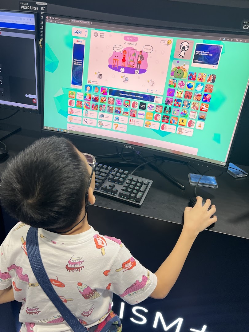 A child plays a game on a large PRISM+ monitor display inside the store.