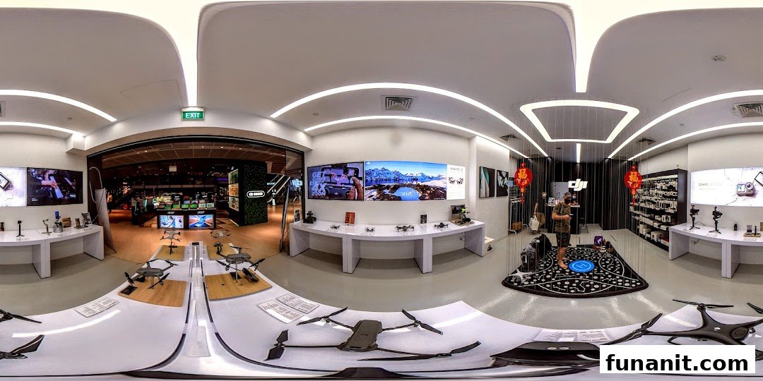 A wide-angle interior view of a modern electronics store featuring drones, cameras, and interactive displays.