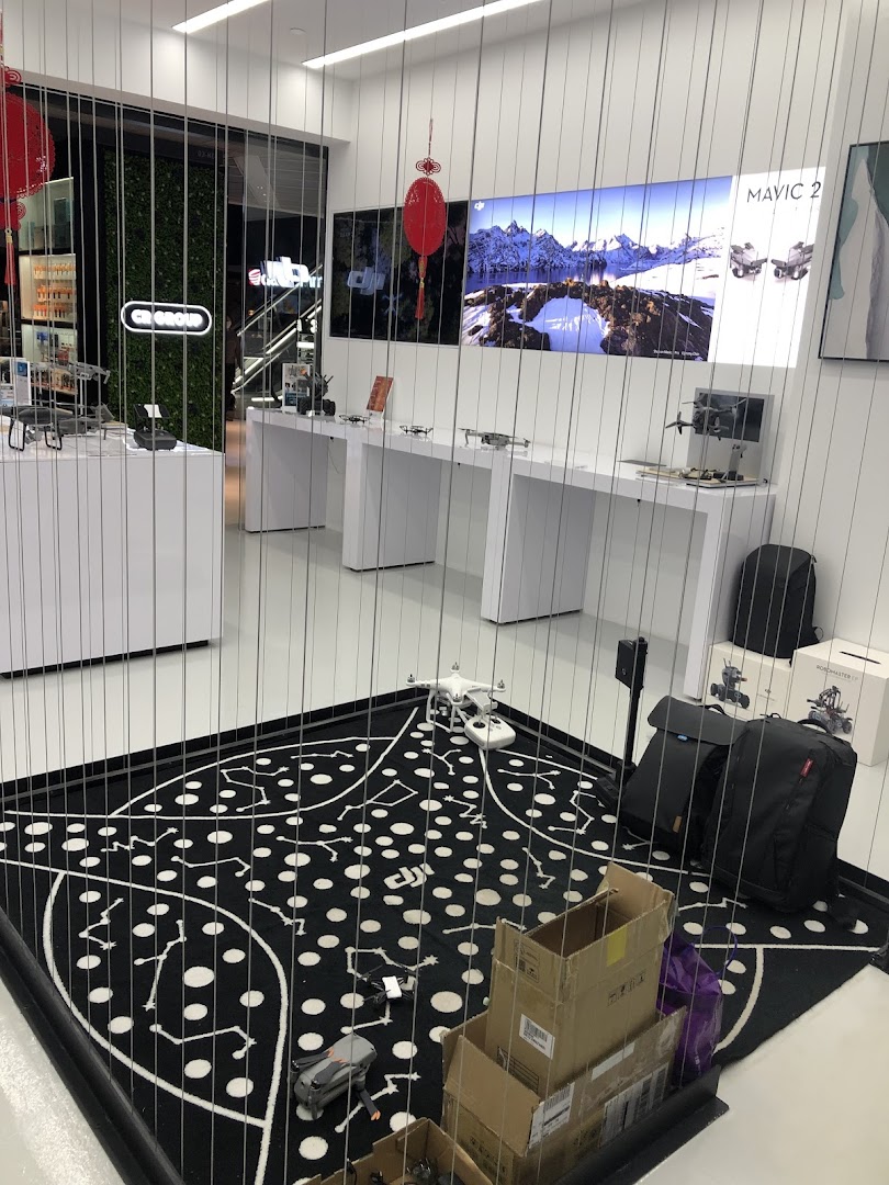 An interior view of Propeller - Funan, showcasing DJI drones and accessories in a modern, brightly lit retail space.