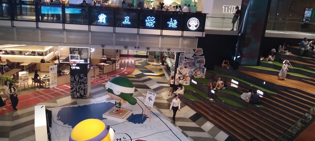 An overhead view of a vibrant multi-level mall interior featuring shops, seating areas, and a central display.
