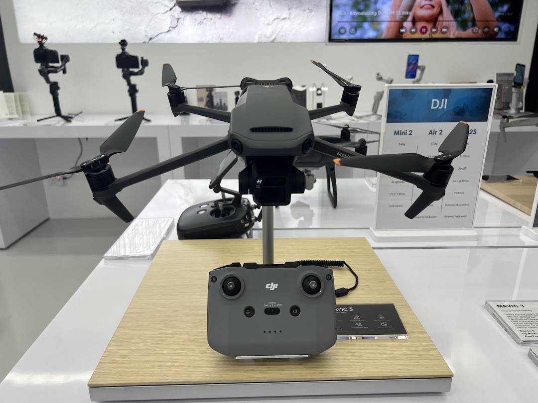 A DJI Mavic 3 drone and its controller are displayed in a modern retail store.