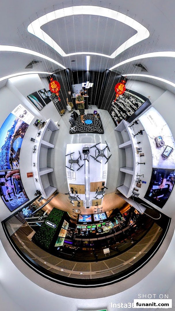 A wide-angle interior view of a modern tech store showcasing drones, cameras, and accessories on display.