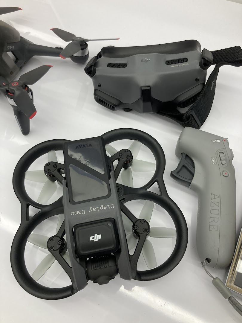 A display of DJI FPV and Avata drones with goggles and motion controller.