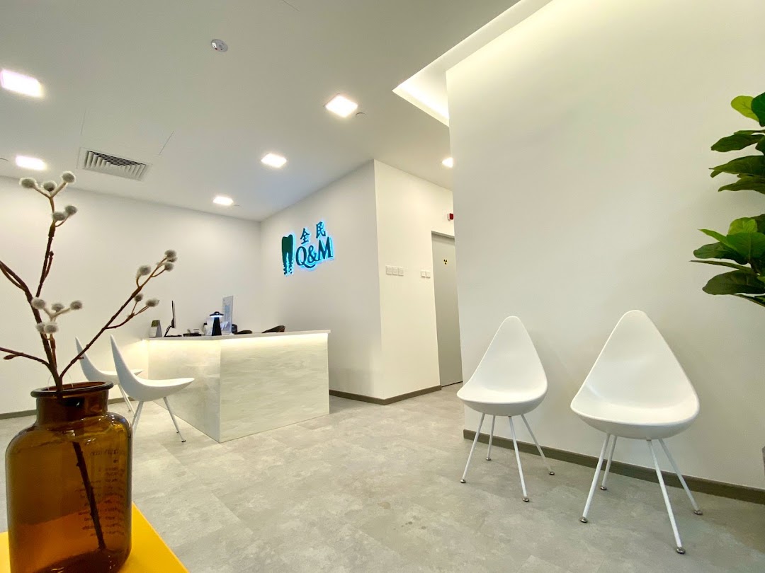 A modern and clean reception area of Q&M Dental Centre with a reception desk and waiting chairs.