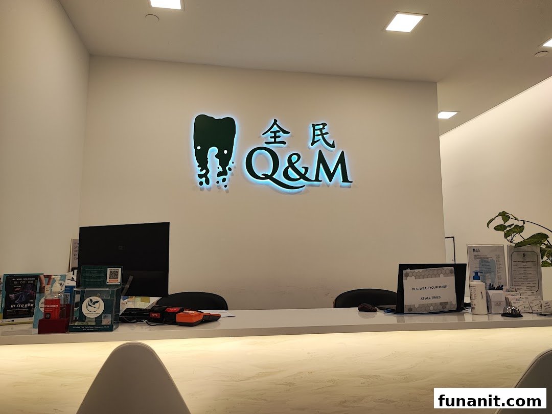 The brightly lit reception area of Q&M Dental Centre, featuring their prominent logo and a clean desk.