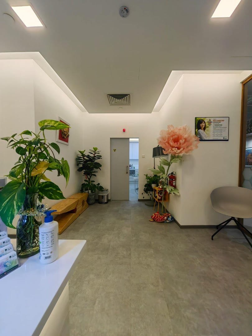 A bright, modern interior hallway of a dental center with plants and a large decorative flower.