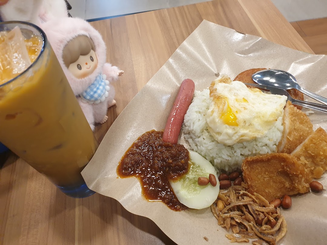 A delicious plate of Nasi Lemak with various toppings and an iced beverage at Qi Ji.