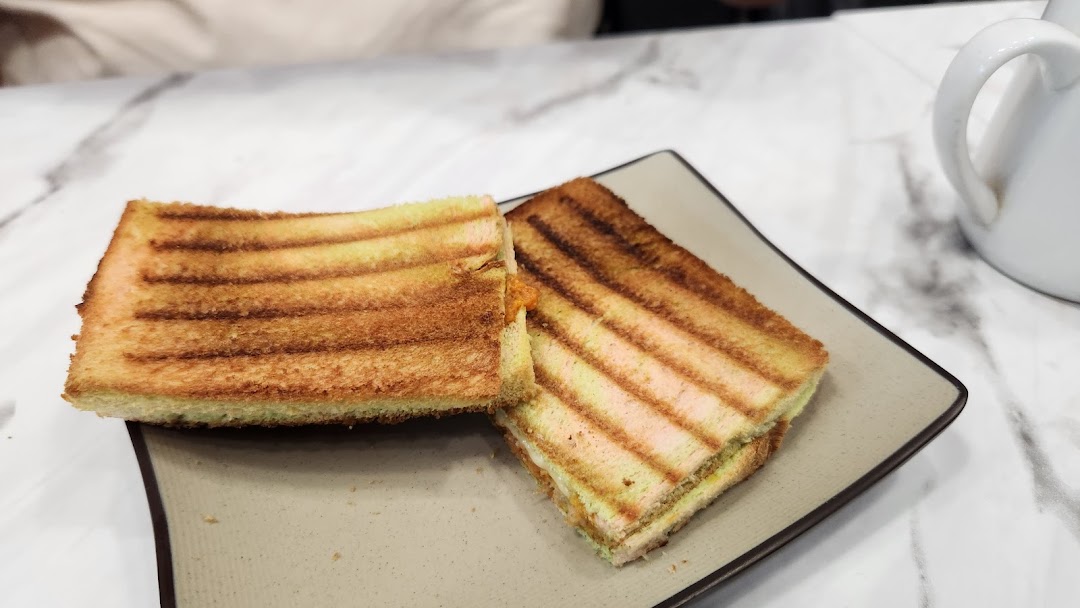 Two pieces of golden-brown grilled toast with filling, served on a plate.