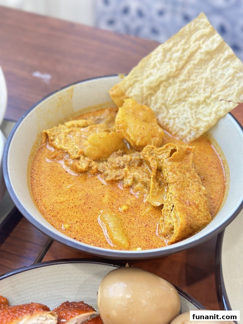 A vibrant bowl of curry with potatoes and tofu skin, alongside other delicious dishes.