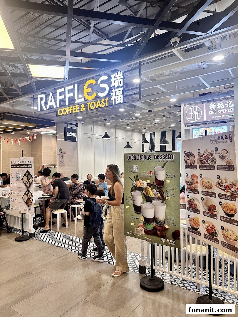 The brightly lit entrance of Raffles Coffee & Toast, featuring its signage and promotional displays.