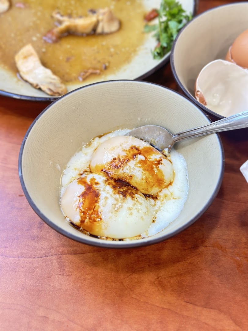 A close-up of two perfectly cooked soft-boiled eggs with soy sauce in a bowl.
