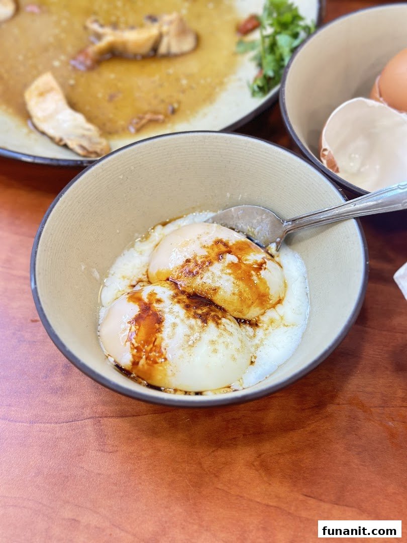 A close-up of two perfectly cooked soft-boiled eggs with soy sauce in a bowl.
