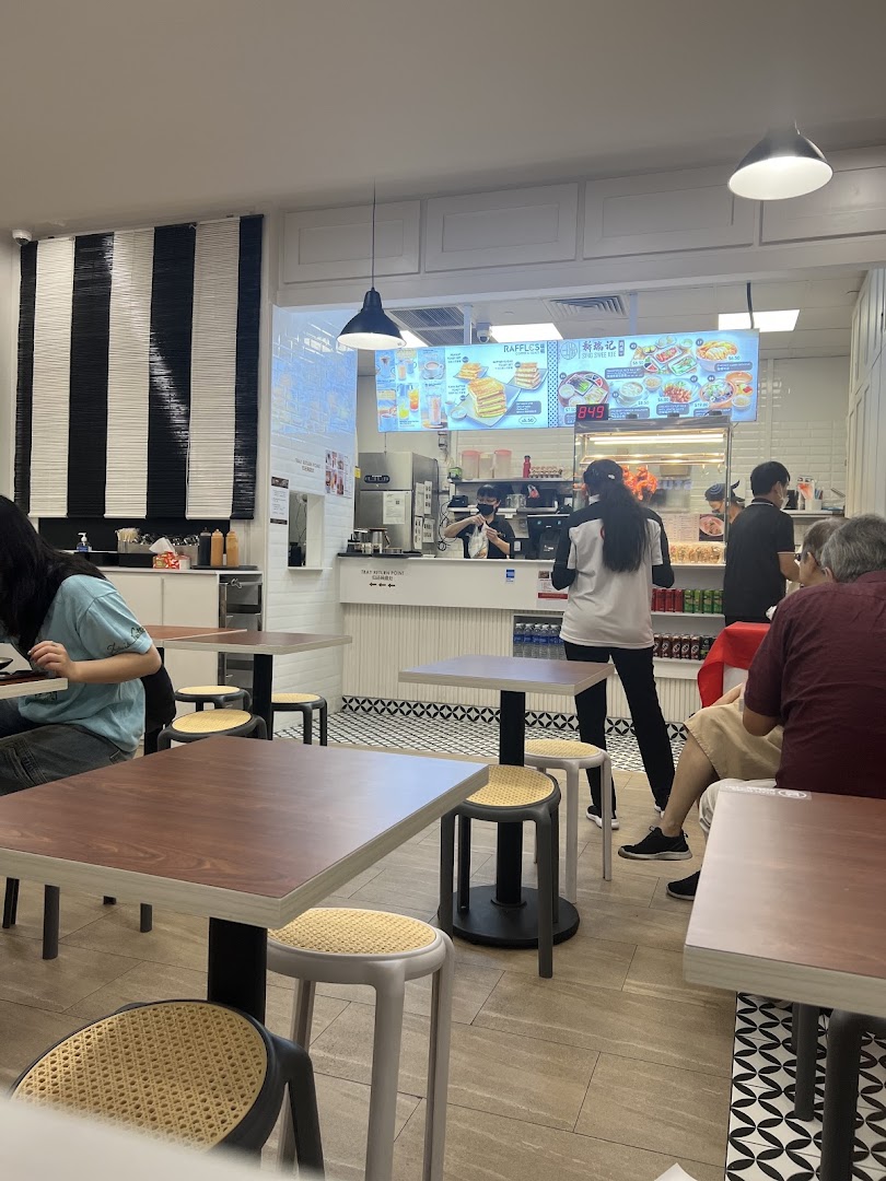 Interior view of Raffles Coffee and Toast, showing customers, staff, and the counter area.