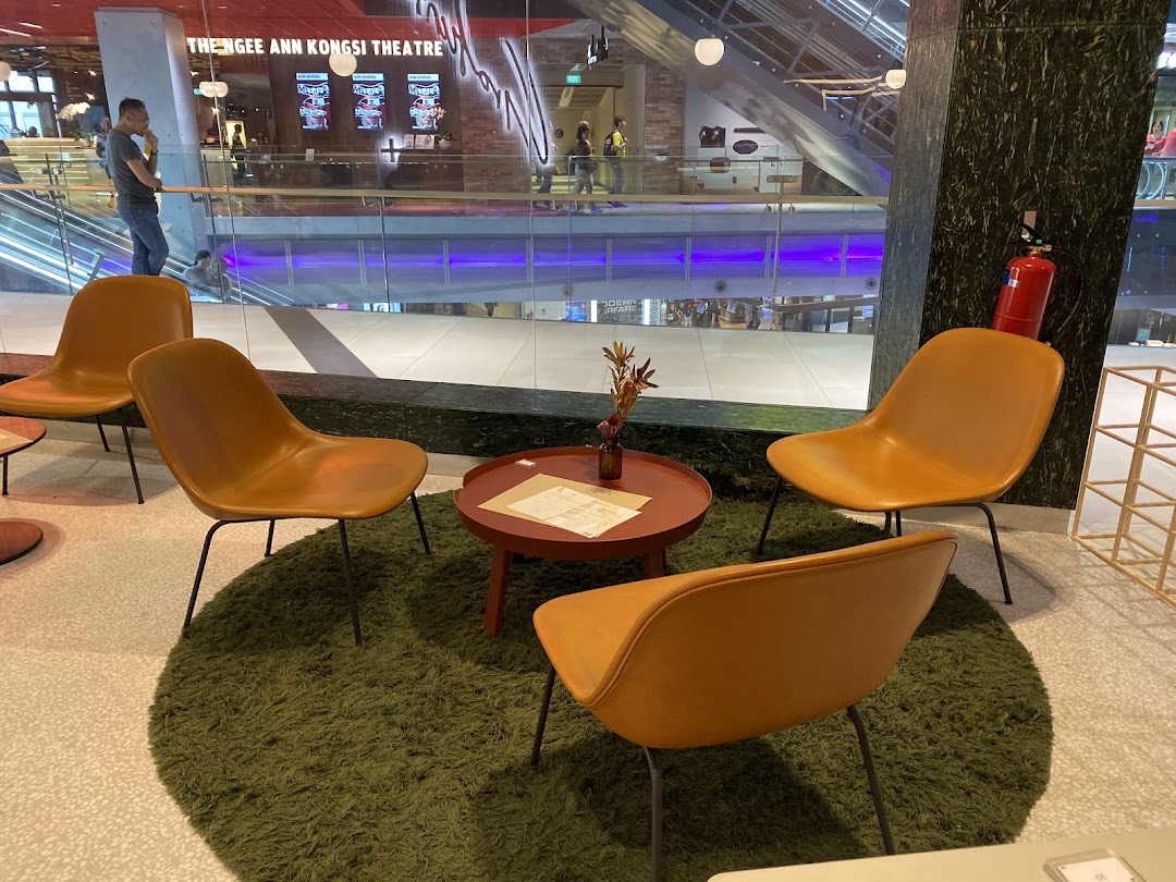A cozy seating area with modern chairs and a table, offering a view of the bustling mall interior.