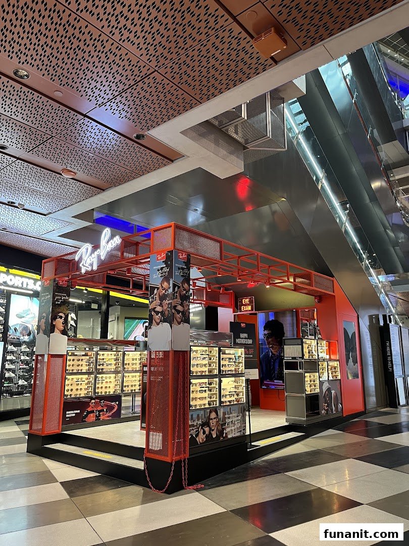 A vibrant Ray-Ban kiosk showcasing a wide range of sunglasses and offering eye exams in a modern mall setting.