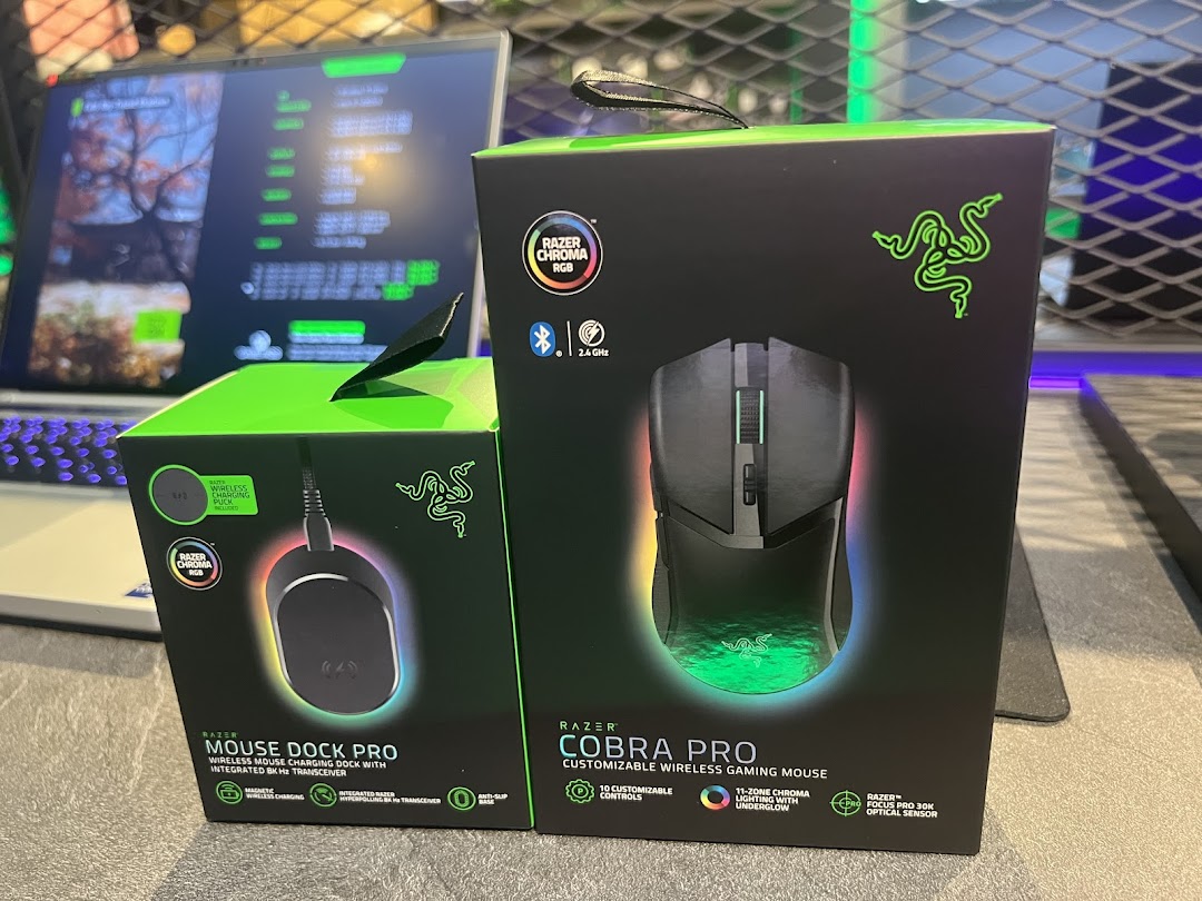 Two Razer product boxes, Mouse Dock Pro and Cobra Pro, displayed with a laptop.
