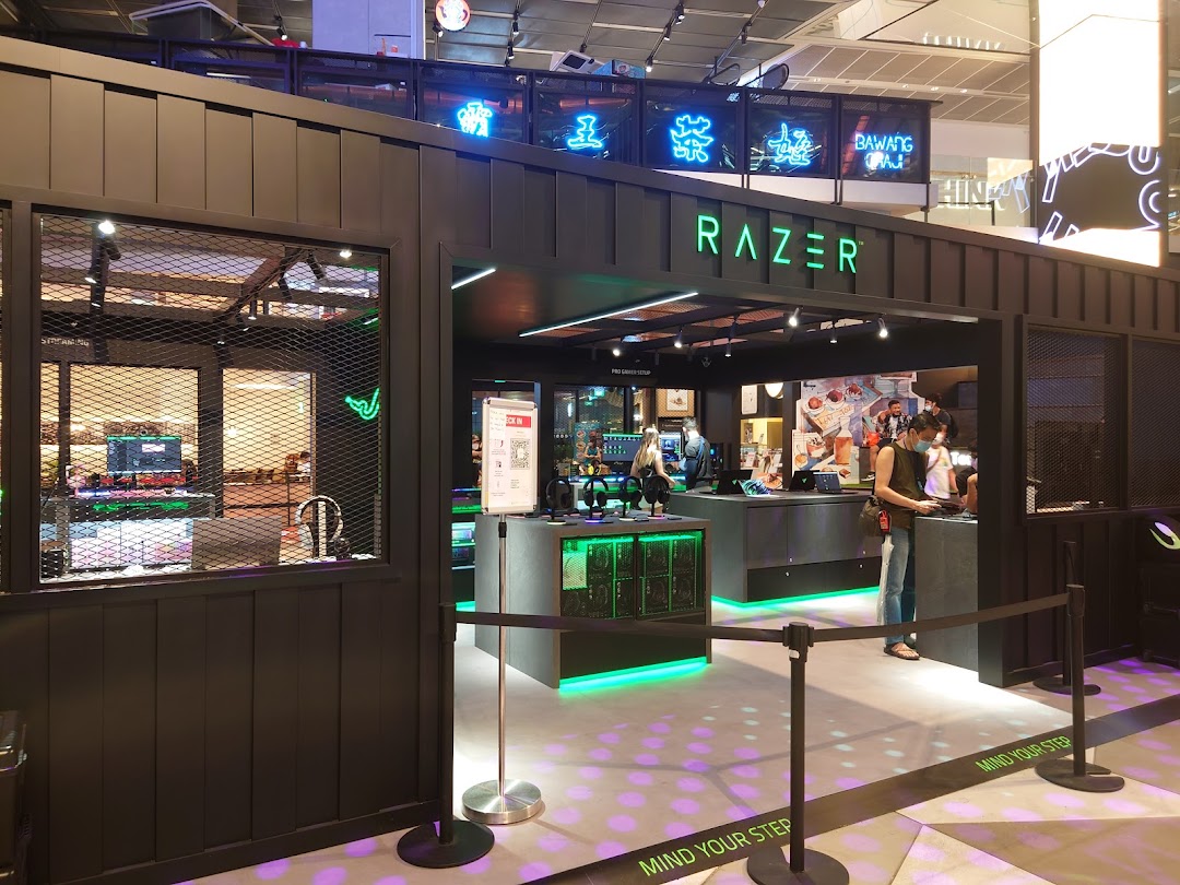 The vibrant entrance of RazerStore Funan, showcasing its signature green lighting and gaming setups.