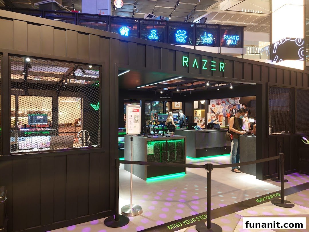 The vibrant entrance of RazerStore Funan, showcasing its signature green lighting and gaming setups.